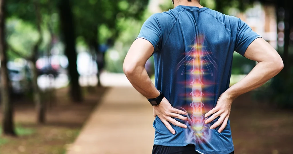Man holding lower back with highlighted spine pain outdoors