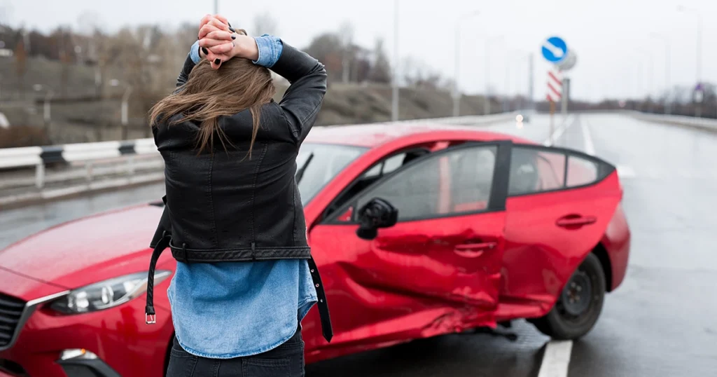 Driver holding their head in distress after a car accident, assessing the damage.