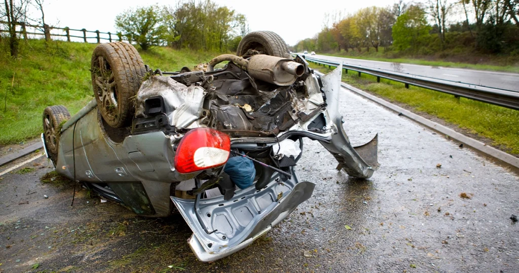 Fatal car accident with a flipped vehicle on the road.